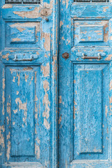 a blue wooden door is a peeling color