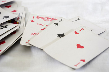 Four aces on a white background and scattered game cards.