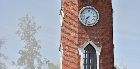 large and tall brick clock tower with blue sky background, with text space