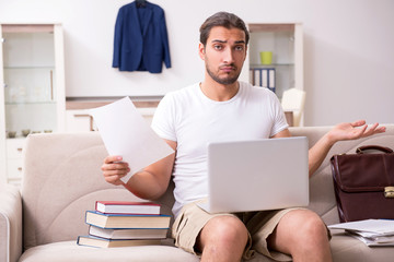 Young male student preparing for exams at home