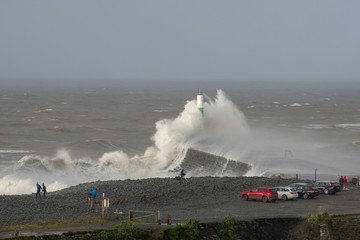Fototapeta na wymiar Storm Dennis creates big waves that crash into the seaside town of Aberystwyth , Wales.