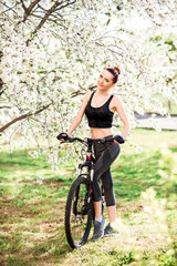 Fototapeta na wymiar girl in nature with a Bicycle in good shape. Sports lifestyle and healthy lifestyle concept