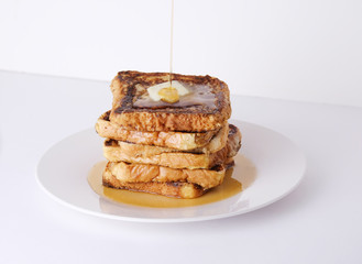 Stack of french toast bread with butter and syrup for breakfast food on white background.
