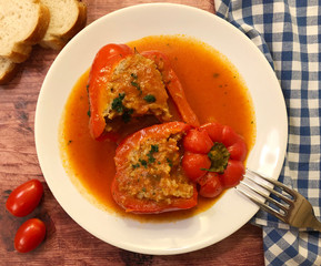 Stuffed bell peppers with minced beef, rice, onions and herbs as filling in tomato sauce. 