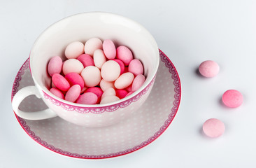 Sweet pink round candies, drops in cup