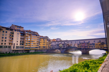 Obraz premium A view along the Arno River towards the Ponte Vecchio in Florence, Italy.