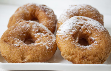donut, polish donut, classic donut, old-fashioned donut, one donut with icing sugar on a white background, close-up. Copy space. bitten donuts