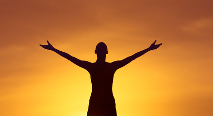 Fototapeta premium Young woman at sunset feeling at peace and full of gratitude and hope. 