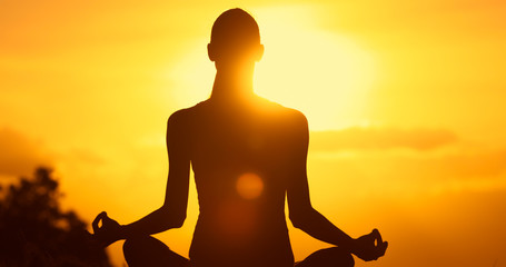 Woman meditating in a a beautiful peaceful nature setting. 