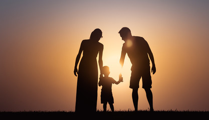 Mother, father, child walking together at sunset. Happy loving family, parenting concept. 