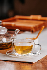 Cup of hot tea with rock sugar, dry tea leaves served in thermo glass tea cup
