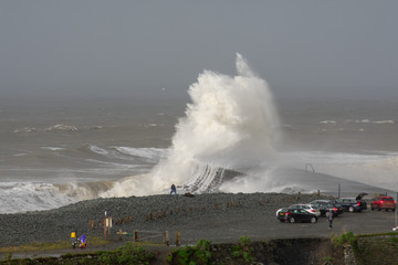 Fototapeta na wymiar Storm Dennis creates big waves that crash into the seaside town of Aberystwyth , Wales.