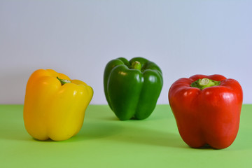 Red, green and yellow colored pepper on a colorful background. Concept: healthy food vegetables