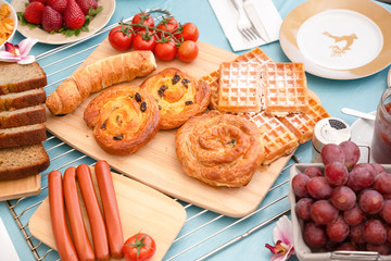 Breakfast Served in the morning with cereal bread, raisin bread, banana bread, sausage bread, chicken sausage, Natural corn flake breakfast cereal in cups and fruit on the breakfast table every day