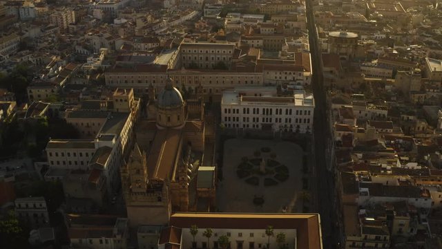 Cinematic flight early sunny morning over the Cattadrale Santa Vergine Maria Assunta, Palazzo dei Normanni, Cappella Palatina, in the historic part of Palermo. Sicily, Italy. May 2019. Aerial shot