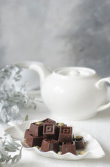 Homemade chocolates with a teapot and a cup of coffee