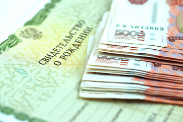 Russian money and birth certificate, concept of increasing birth rate