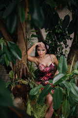 A young beautiful brunette posing among dense thickets of jungle and rainforest. Spa