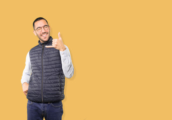 Amazed young man making a gesture of calling with the hand
