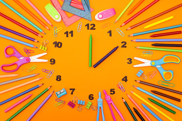 Fototapeta premium Creative clock made of school and office supplies with clock wise 