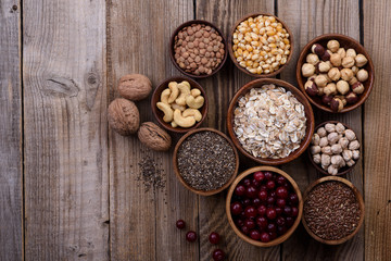 Obraz na płótnie Canvas Different superfoods set, seeds, nuts, grains, cranberries, oatmeal. Top view. Vegetarian healthy diet concept.