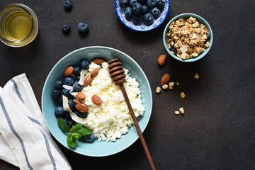 Beautiful breakfast - cottage cheese, berries and honey on the kitchen table. Good morning.