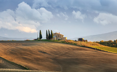Amazing clouds, small farm house and alley of cypress trees before the storm. Val d'orcia. Italian...