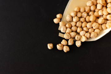 White chickpeas in papyrus cone bag on black backgroud with copy space. Live well by eating healthy. Vegetable protein source. 