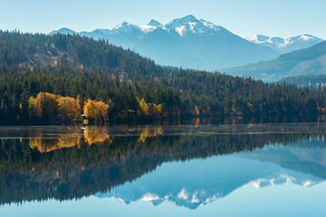 Fototapeta na wymiar Snowy mountains reflected in Gun Lake in British Columbia, Canada