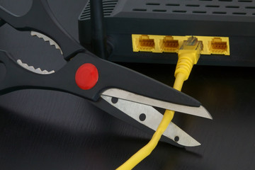A pair of scissors are shown just before cutting the internet connection provided by a yellow...