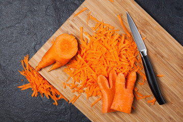 A fashion trend is eating deformed and ugly vegetables. Grated carrots on a cutting board. Closeup