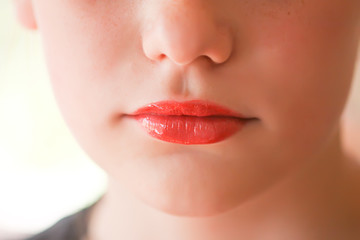 Obraz premium Young attractive teenager girl's face view with lipstick on lips