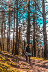 Fototapeta premium A young woman with a backpack walking along the path of Mount Adarra in Guipuzcoa on a sunny morning. Basque Country