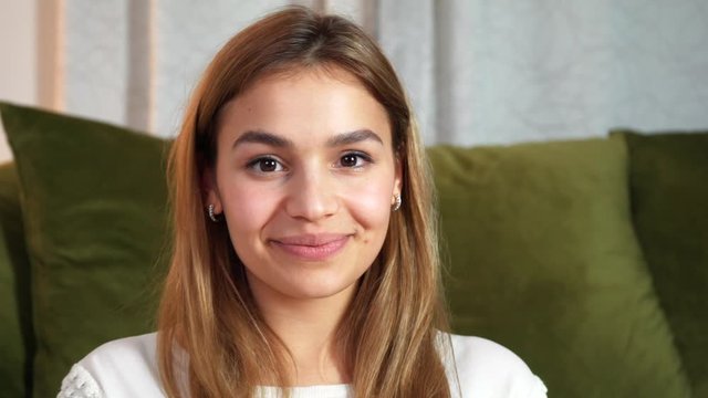 Young playful woman looking into camera and having fun. Attractive model showing different facial expressions: being cute, blinking, smiling, teasing, showing tongue, hiding, asking, laughing.