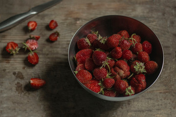 strawberries in a bowl on wooden table