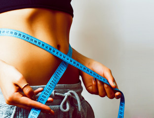 woman measuring waist with tape on knot like a gift closeup on white background