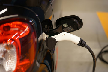Detail of electric car at charging station, ecology concept