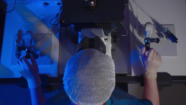 In a Modern Laboratory Scientist Conduct Experiments. The embryologist Examines Samples with a Microscope. View Top