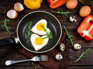 fried eggs on a skillet on a wooden background