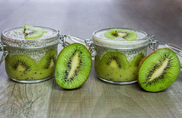 Healthy dessert: kiwi fruit mousse covered with pudding prepared from chia seeds and an almond drink decorated with kiwi fruit