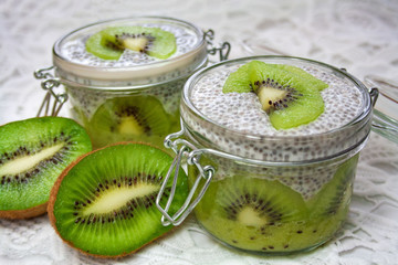 Naklejka na ściany i meble Healthy dessert: kiwi fruit mousse covered with pudding prepared from chia seeds and an almond drink decorated with kiwi fruit