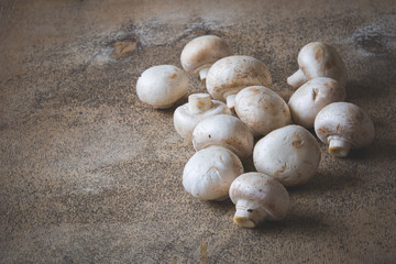 A bunch of fresh champignons on a wooden table. Selective focus. Toning