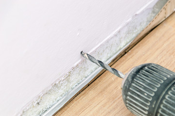 Beginning of drilling in the wall. A close up on a drill.