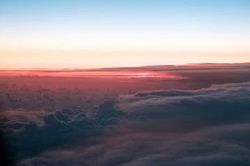 Sunset above the clouds. The view of the sunset from the plane. Rays of the sun through the clouds. Выделите текст, чтобы посмотреть примеры