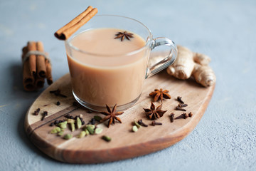 Traditional indian drink - masala tea with spices on grey stone background