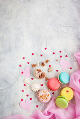 Colorful macarons and hearts on gray background, top view, Valentine concept