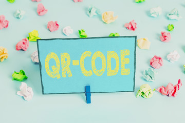 Writing note showing Qr Code. Business concept for the trademark for a type of matrix barcode A machinereadable code Colored crumpled papers empty reminder blue floor background clothespin