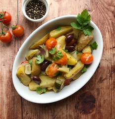 Golden crispy oven vegetables. The side dishes are potatoes, cherry tomatoes, bell peppers, olives, onions, zucchini, garlic, pasrley herb, seasoned with olive oil, lemon juice, salt and black pepper.