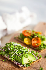 Avocado rye toasts with green herbs, onion and cherry tomatoes, healthy food