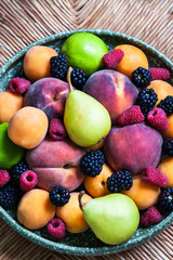 Plate of various summer fresh ripe berries and fruits, close up